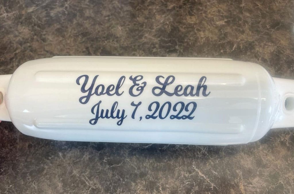 White bouy that reads: Yoel & Leah July 7th 2022